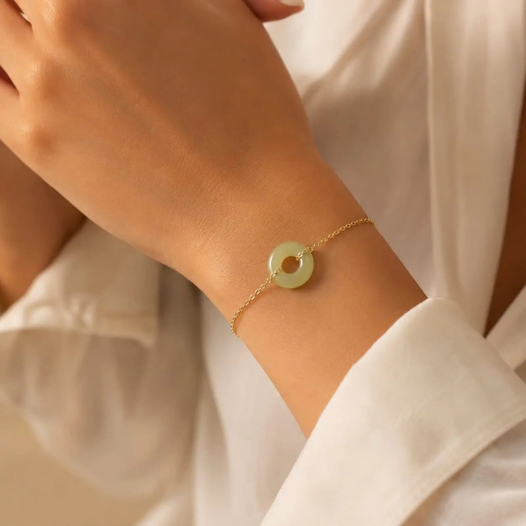 Close-up of an olive green jade donut bracelet on the wrist